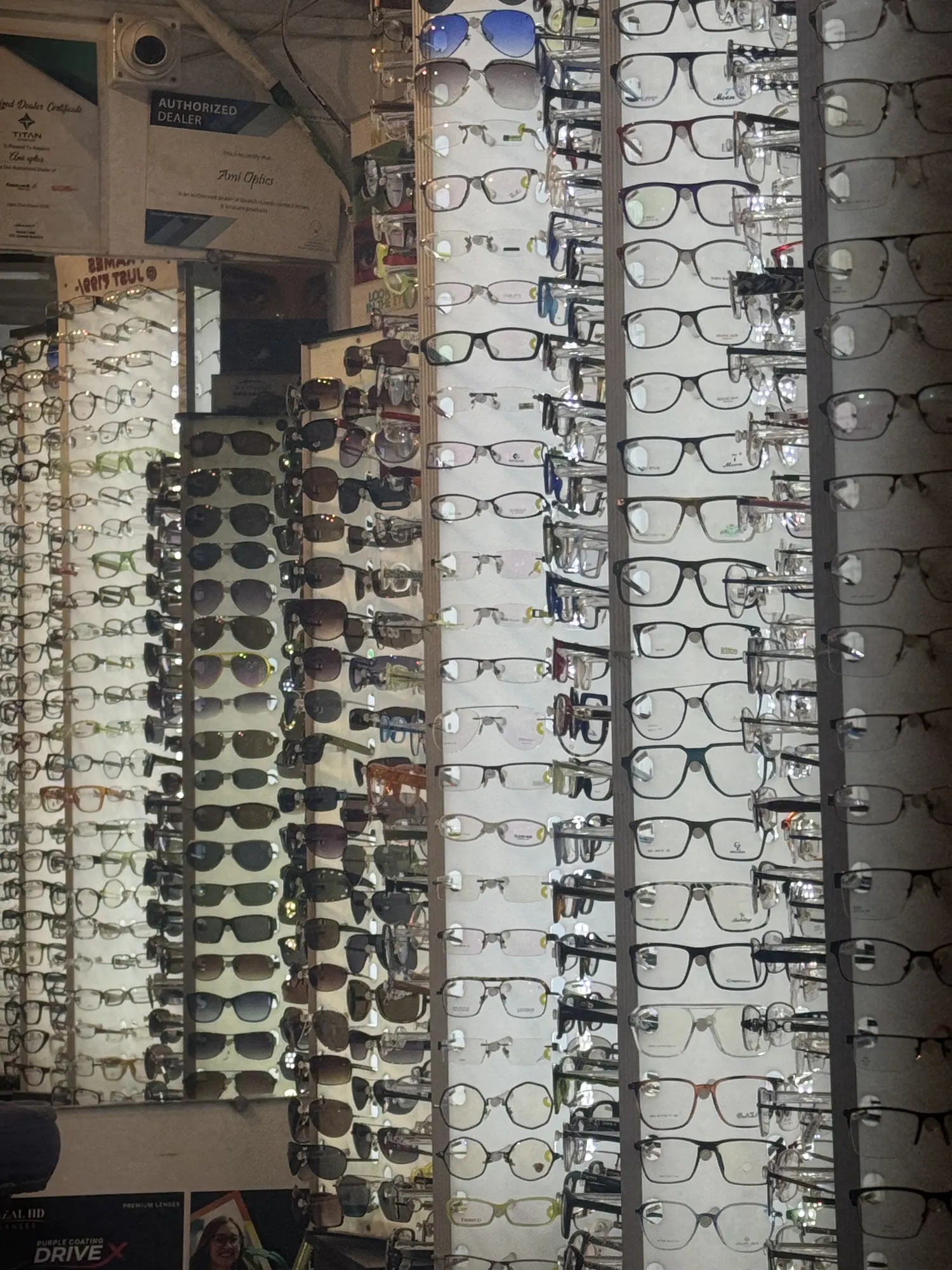 The frame wall at Ami Optics, lined with metal and acetate spectacle frames